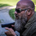 hearing protection in ears of bearded man shooting at range