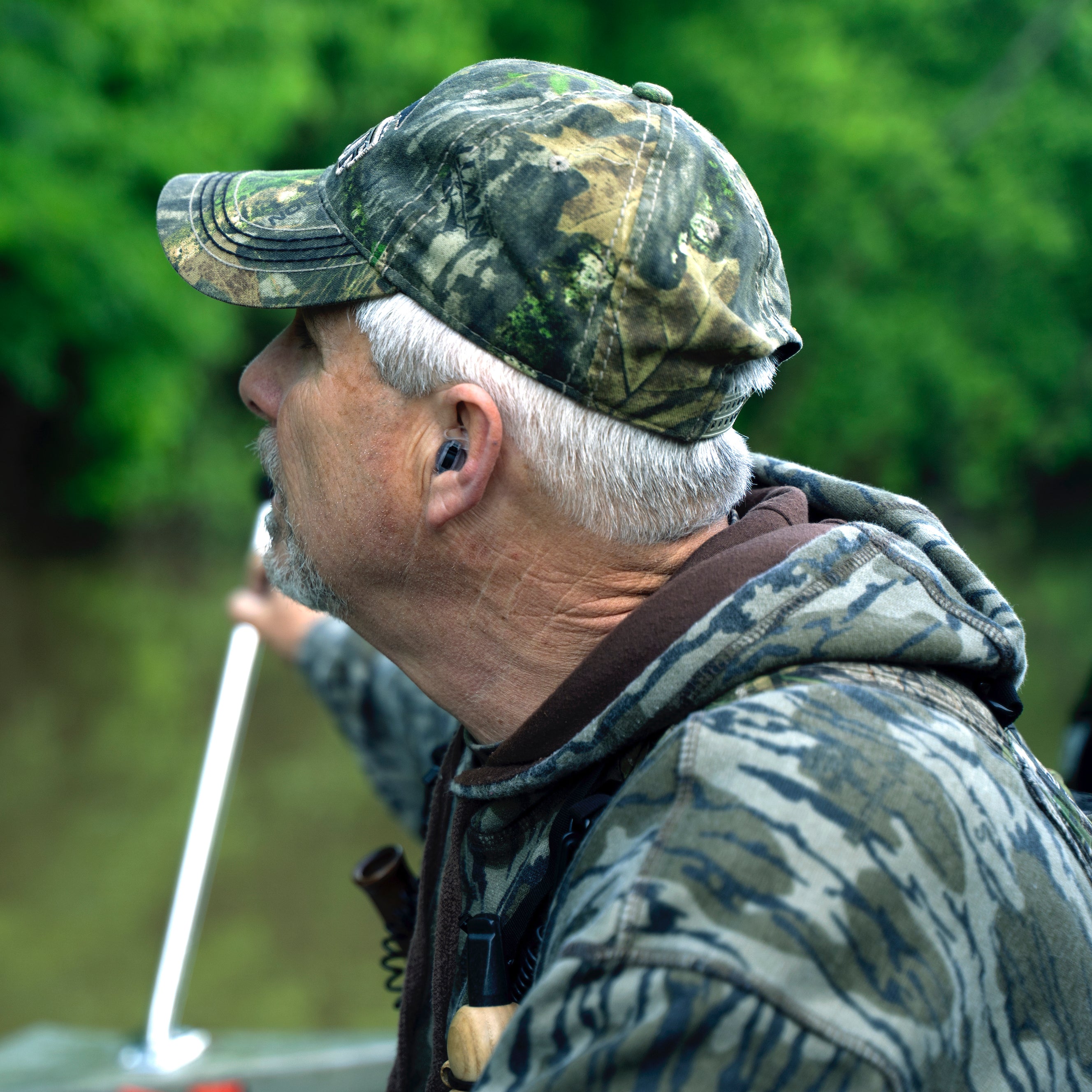 TETRA AmpPods hearing amplifiers in ears of turkey hunter in boat